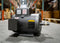 A Baldor AC electric motor sits on the smooth grey concrete floor of a large warehouse.